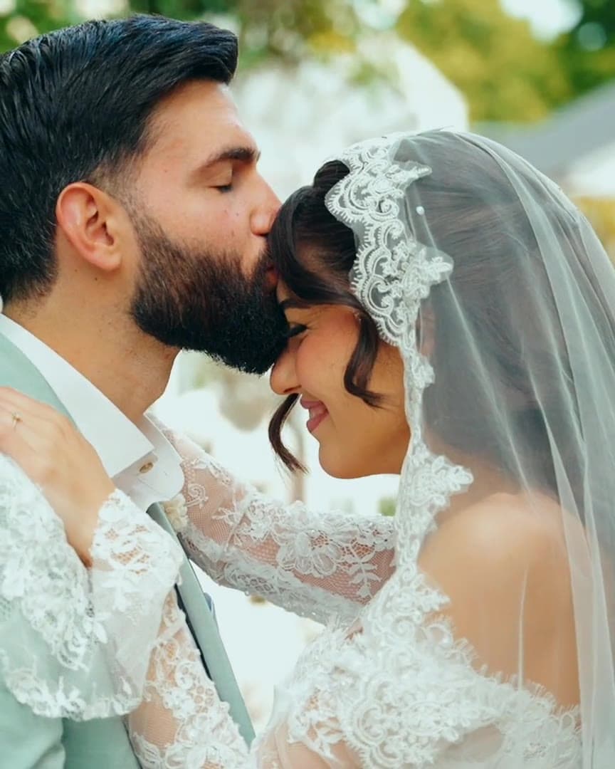 Bräutigam küsst die Braut auf die Stirn – Ausschnitt aus einem Wedding Film